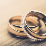 Close-up of two intertwined wedding rings.
