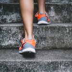 Walking up stairs in orange sneakers.