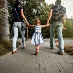 Family walking together on a paved path.