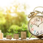 Clock, coins, and plants symbolizing financial growth.