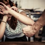 Person shielding face from threatening fist.