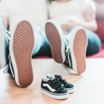 Family shoes with baby sneakers on table.
