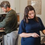 Couple cooking together in kitchen, smiling.
